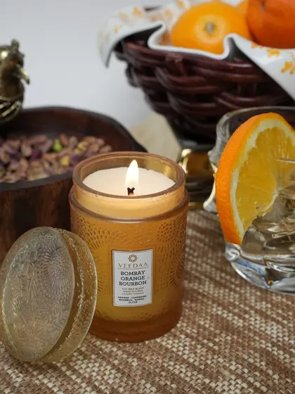 Our Bombay Orange Bourbon candle, set amongst fresh oranges and pistachios. The fragrance is a rich blend of citrus and warmth, perfect for creating a cozy and welcoming atmosphere.