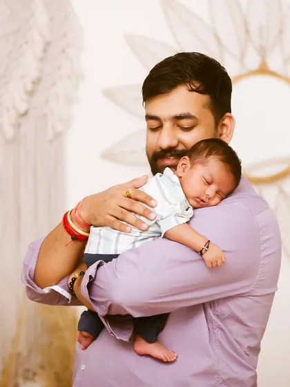 A father's gentle embrace. This portrait captures the peaceful moment of a newborn sleeping soundly on their dad's shoulder.