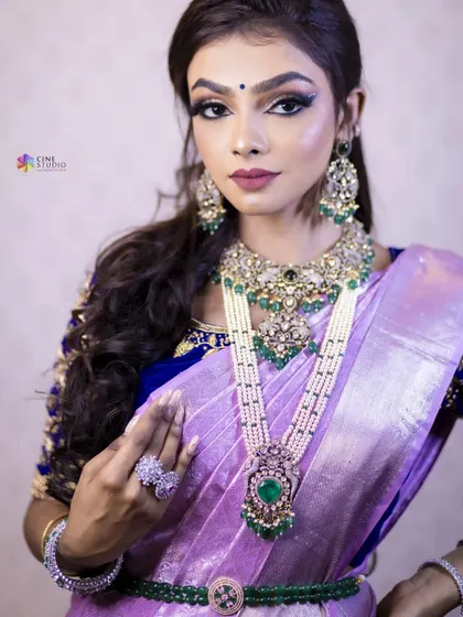 This Victorian-style set with green stones and pearls offers a different kind of festive elegance. It is paired with a lavender saree for a unique and modern celebratory look.