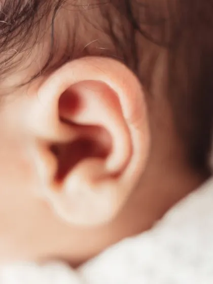 A macro shot of a newborn's tiny, intricate ear.