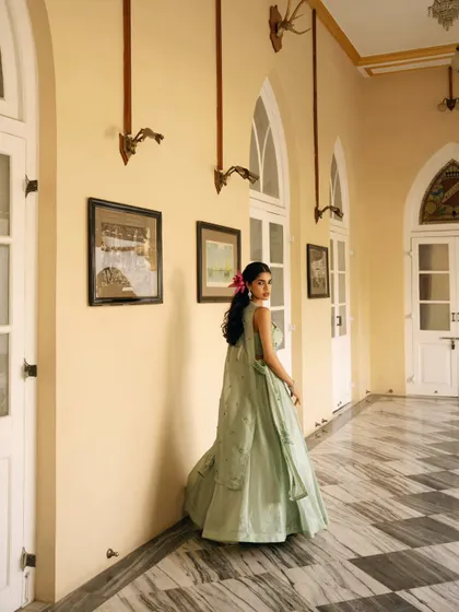 A candid-style shot in a beautiful corridor, capturing movement and the flow of the lehenga. This adds a dynamic element to a lookbook.