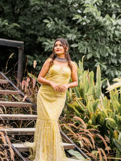 A stunning yellow fishtail gown with intricate sequin work. This is a rental piece, perfect for when you want to shine at a special event without buying a new outfit.