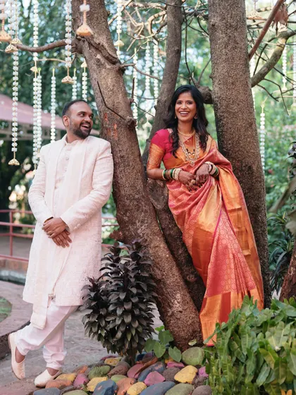 A playful and stylish pose under a decorated tree, showing the couple's personalities shining through during their outdoor engagement shoot.