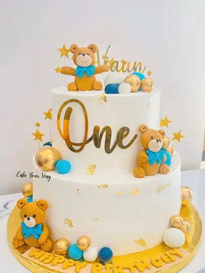 Twinkle, twinkle, little one. This two-tier teddy bear cake in white, blue, and gold is a classic and elegant choice for a first birthday.