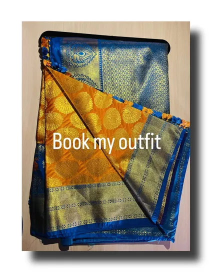The accompanying blue and orange silk saree, folded to show the rich gold brocade work on the pallu.