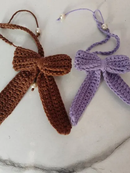 Another view of the lavender and cocoa crochet bows. They are perfect for tying in hair, decorating bags, or even for gift wrapping.