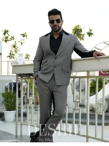 This full-length shot shows the complete grey and black suit, a perfect example of modern power dressing.
