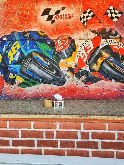 We captured the thrilling speed of MotoGP with this vibrant mural at Burnout Café. The artwork depicts two racers leaning into a turn, surrounded by explosive colors and abstract patterns.