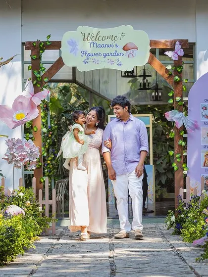 The family making their entrance into Maanvi's flower garden. This photo captures the full effect of the welcoming decor, from the archway to the milestone board.