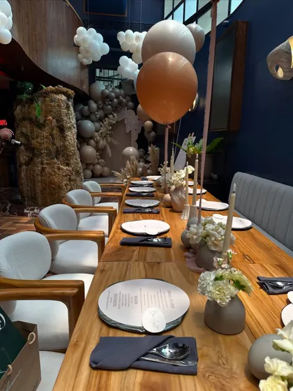 A long view of the dining setup for the "Oh Baby" shower, where clean lines, neutral tones, and minimalist floral arrangements created a feeling of calm elegance.