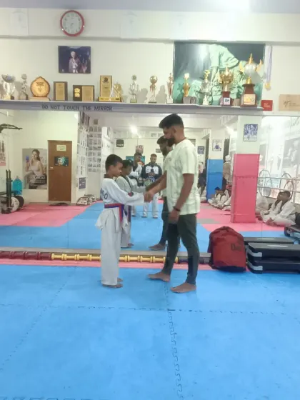 A student receives his red belt.
