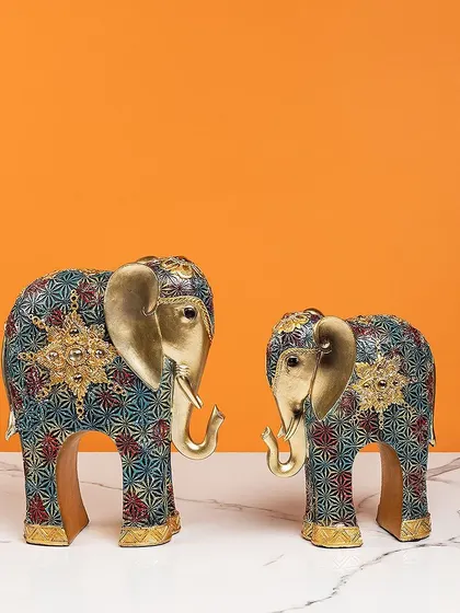 This pair of standing elephants features a unique, modern pattern in shades of blue, red, and gold. They are a contemporary take on a classic symbol, blending artistry with tradition.