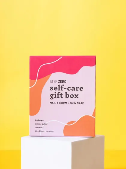 A vibrant shot of the Step Zero self-care gift box on a white pedestal against a bright yellow background. This color-blocking technique makes the product stand out.