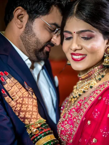 An intimate close-up of the couple. The focus is on their gentle expressions and the intricate details of the bride's jewelry and henna.