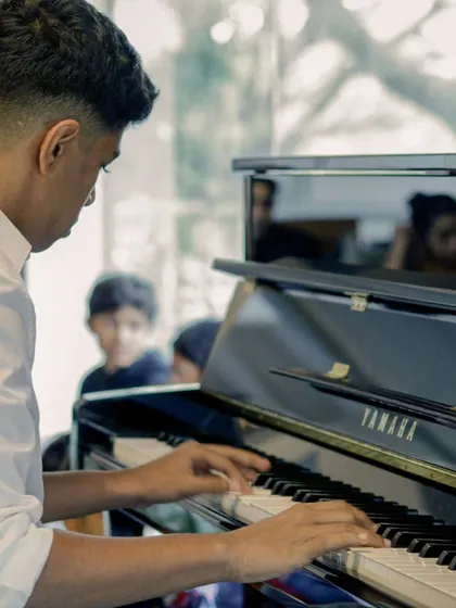 A student pianist deeply focused on his performance. The concentration and skill on display at our recitals is always impressive.