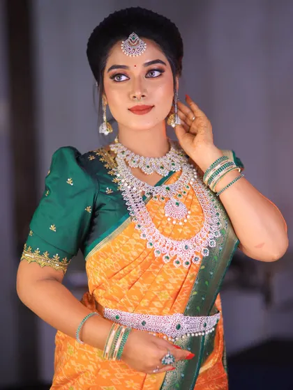 A vibrant yellow and green silk saree styled for a photoshoot. The puff-sleeve blouse adds a traditional touch, and the drape is neat and flattering.