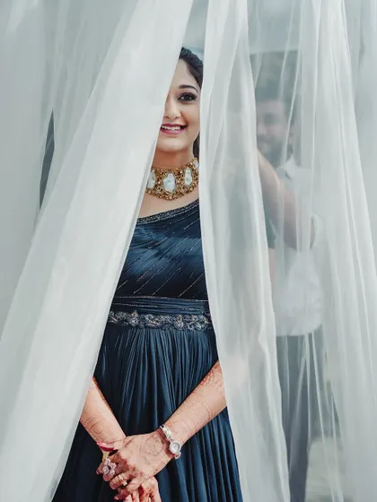 A playful and creative shot of the bride peeking through a curtain.