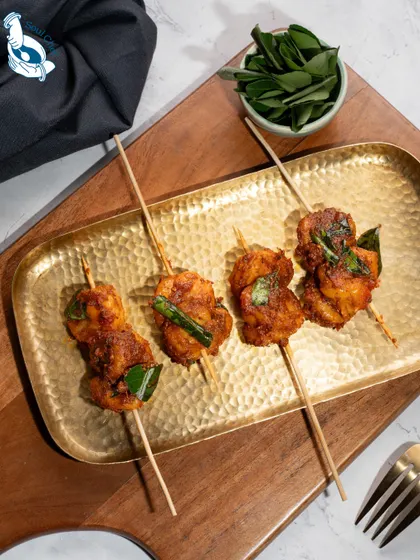 I combine traditional flavors with modern presentation. These Ghee Roast Prawns are served on satay sticks, making them an easy-to-eat and elegant appetizer for cocktail soirées. The authentic coastal spices deliver a bold and memorable flavor.