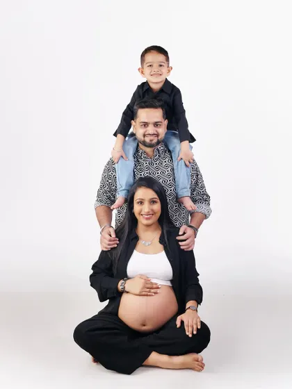 The whole family is excited. This fun pose, with the older brother on dad's shoulders, creates a beautiful human totem pole of love and anticipation for the new arrival.