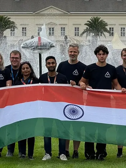 The entire team posing with the Indian flag, all wearing their custom-designed T-shirts.