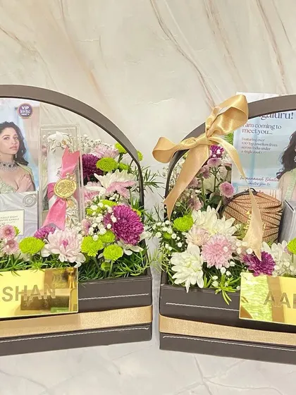 A closer look at the Aabushan PR hampers, highlighting the fresh flowers, custom nameplates, and beautifully presented scroll invites.