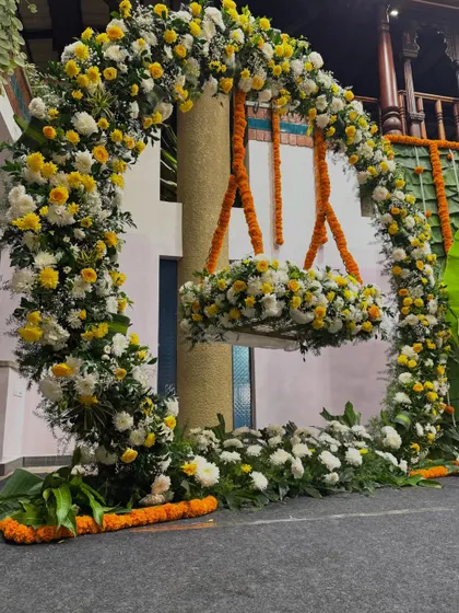 A close-up of a beautiful floral swing, perfect for a naming ceremony. The cradle is adorned with white and yellow flowers, creating a lovely spot for the baby.