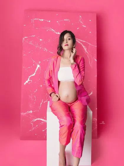 A beautiful seated portrait that exudes confidence and style. The vibrant pink makes this a standout image from a modern maternity session.