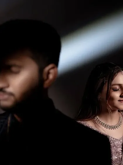 The color version of a creative lighting setup. The single beam of light cuts through the darkness, creating a sense of intimacy and quiet contemplation between the couple.