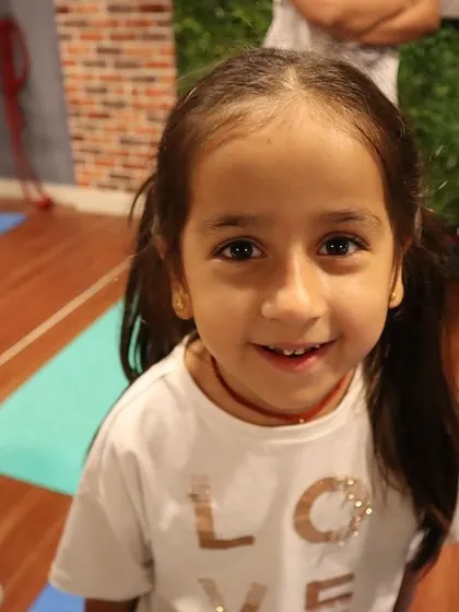 The bright, happy face of a young yogi. Her smile is a reminder of the joy that yoga brings into our lives.