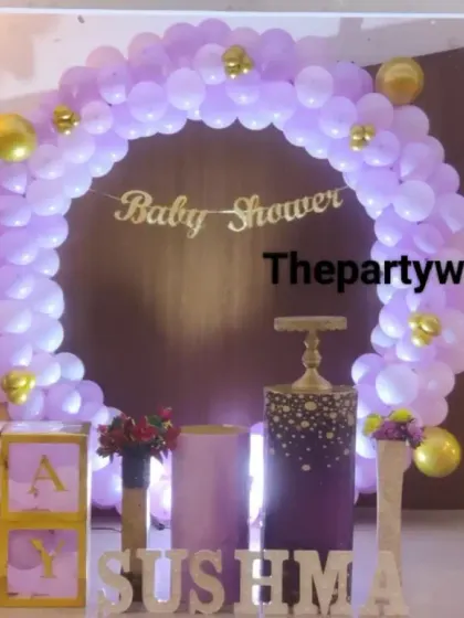 A purple and gold themed baby shower with a 'Baby Shower' banner and 'BABY' blocks.