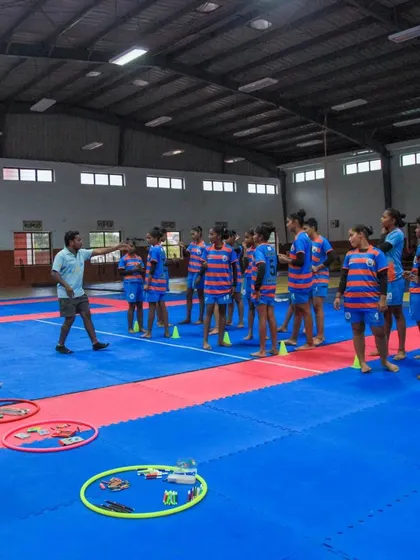 A coach leads the girls' hockey team in fun drills and games. Celebrating special days like Children's Day helps build team morale and a positive, joyful environment.