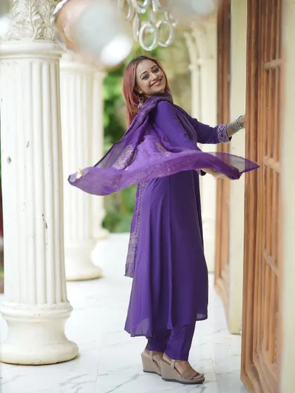 A dynamic, twirling shot of the model in a purple suit, capturing movement and joy.