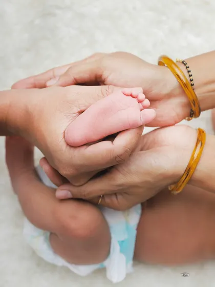 The tiniest feet held safely in loving hands. We focus on capturing these small, beautiful details during our newborn photography sessions.
