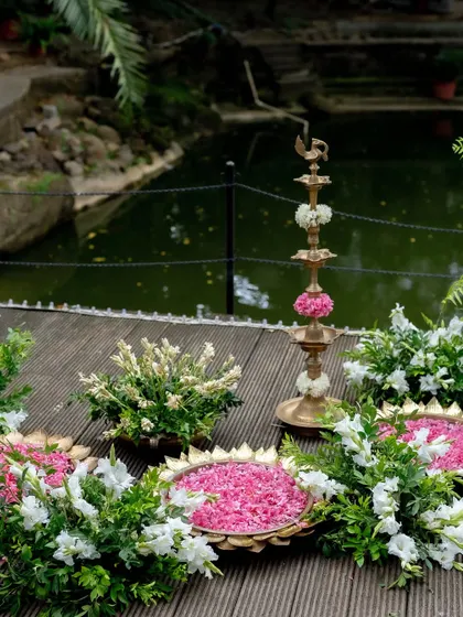 Floral arrangements and traditional lamps decorating the edge of the Kalyani, adding to the serene and sacred atmosphere.