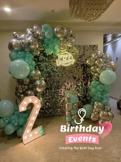 A stylish setup for a 2nd birthday, proving that sequin walls are for all ages. This one features a silver wall with a mint green and silver balloon arch.
