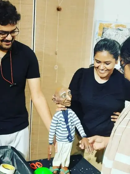 Our team loves sharing our craft with others. Here we are showing a participant the details of our handmade puppet.
