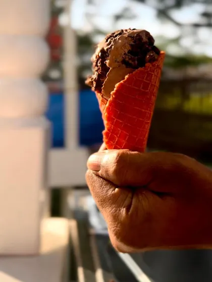 A scoop of my homemade Rocky Road gelato in a bright red cone. I focus on creating flavors that are rich and satisfying, but not overly sweet.