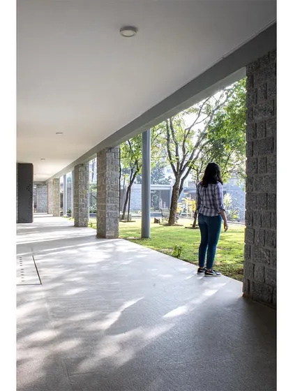 A quiet moment in a wide, shaded corridor, looking out into the garden.