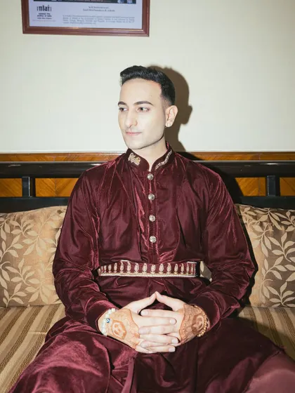 Seated portrait, showcasing the intricate belt and henna details.