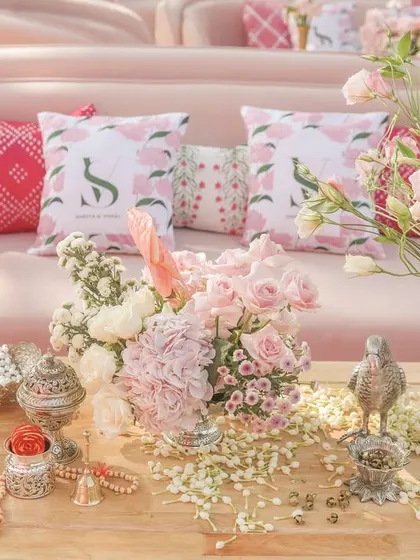 Another beautiful table setting, with a mix of pink florals, traditional silver pieces, and custom cushions.