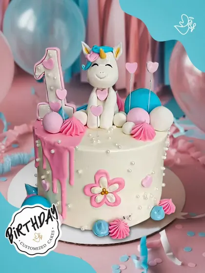 A sweet unicorn cake for a first birthday. Decorated with pink drips, flowers, and hearts, this cake is an adorable way to celebrate a very special milestone.