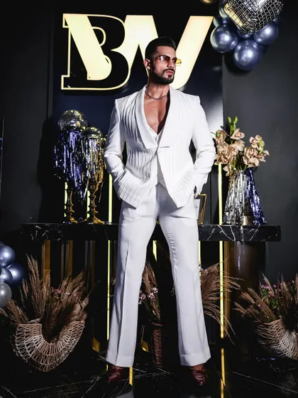 The complete all-white three-piece suit, featuring a unique textured jacket with a shawl lapel. The flared trousers add a touch of retro flair, showcasing our ability to execute bold, fashion-forward designs.