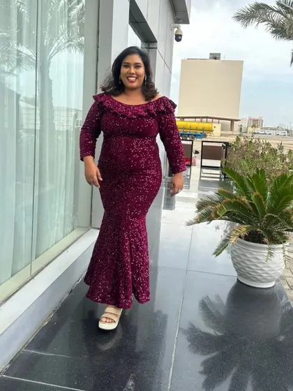 A candid walking shot in a stunning sequined gown. This photo captures a moment of happiness and confidence during an outdoor shoot.