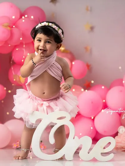 A sweet, shy glance during her first birthday photoshoot. I work to capture all facets of your child's personality, from the big laughs to the quiet, thoughtful moments.
