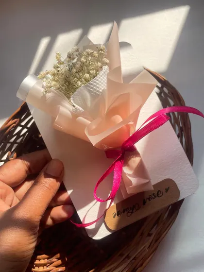 Holding the mini bouquet to show its delicate size. It's perfect as a small token of affection or as an add-on to a larger gift.