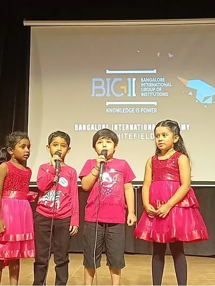 Four young students sing a song during the valedictory program, a testament to the public speaking and performance skills they developed.