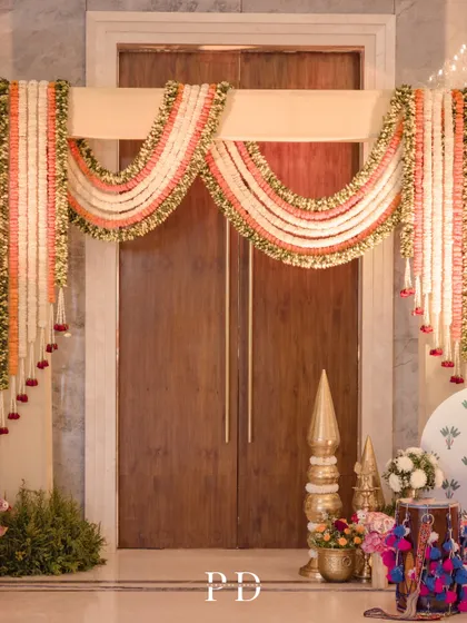 A beautiful floral 'toran' made of tuberose and marigold garlands, a traditional and auspicious way to welcome guests to a wedding ceremony.