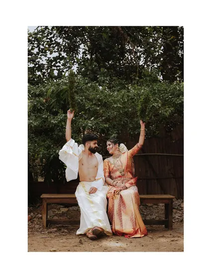 A playful and fun portrait of a couple on a bench after their wedding ceremony.