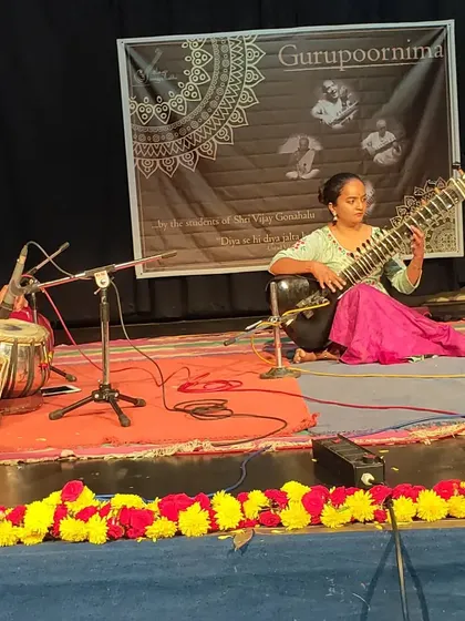A student performing on stage, showcasing her progress. Every student at Alaap Sangeet Sabha gets opportunities to perform in front of a supportive audience.