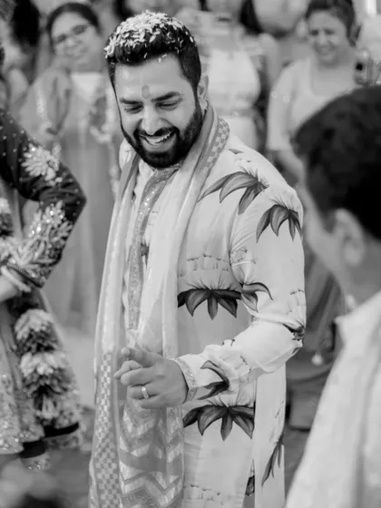 A candid black and white shot of the groom enjoying his Haldi ceremony.